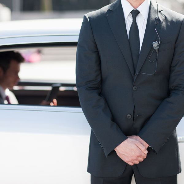 man in suit standing outside car
